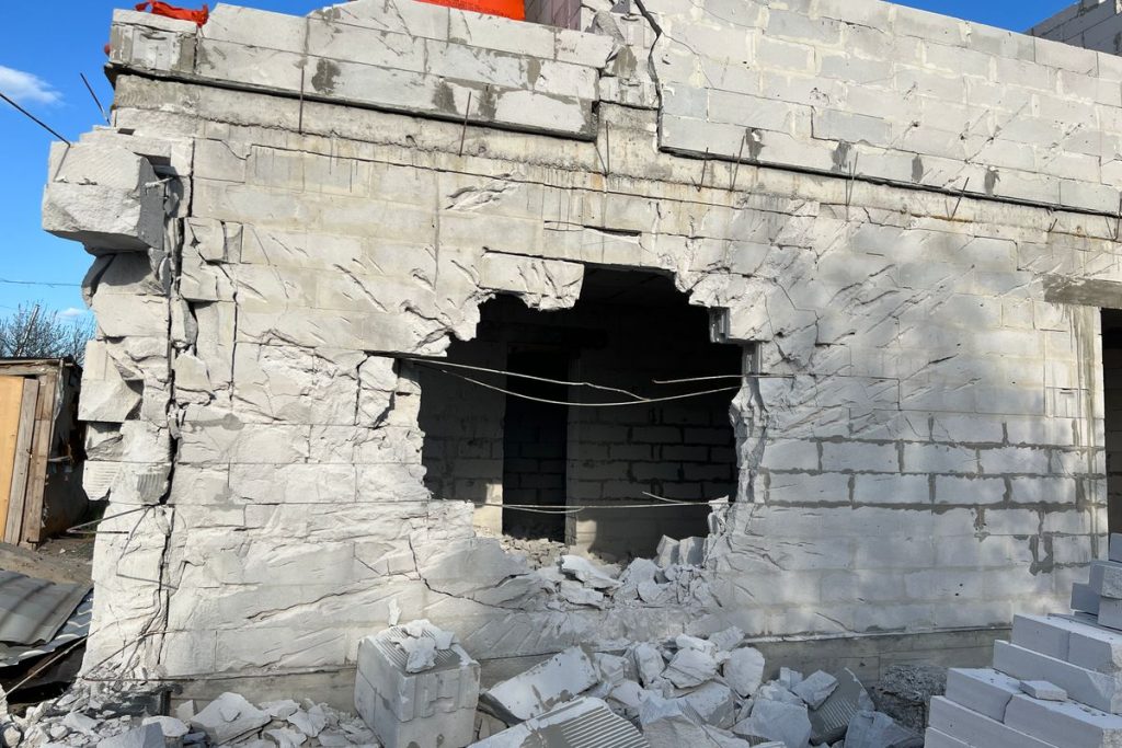 Masonry wall with structural impact damage and rubble after a vehicle or falling object strike